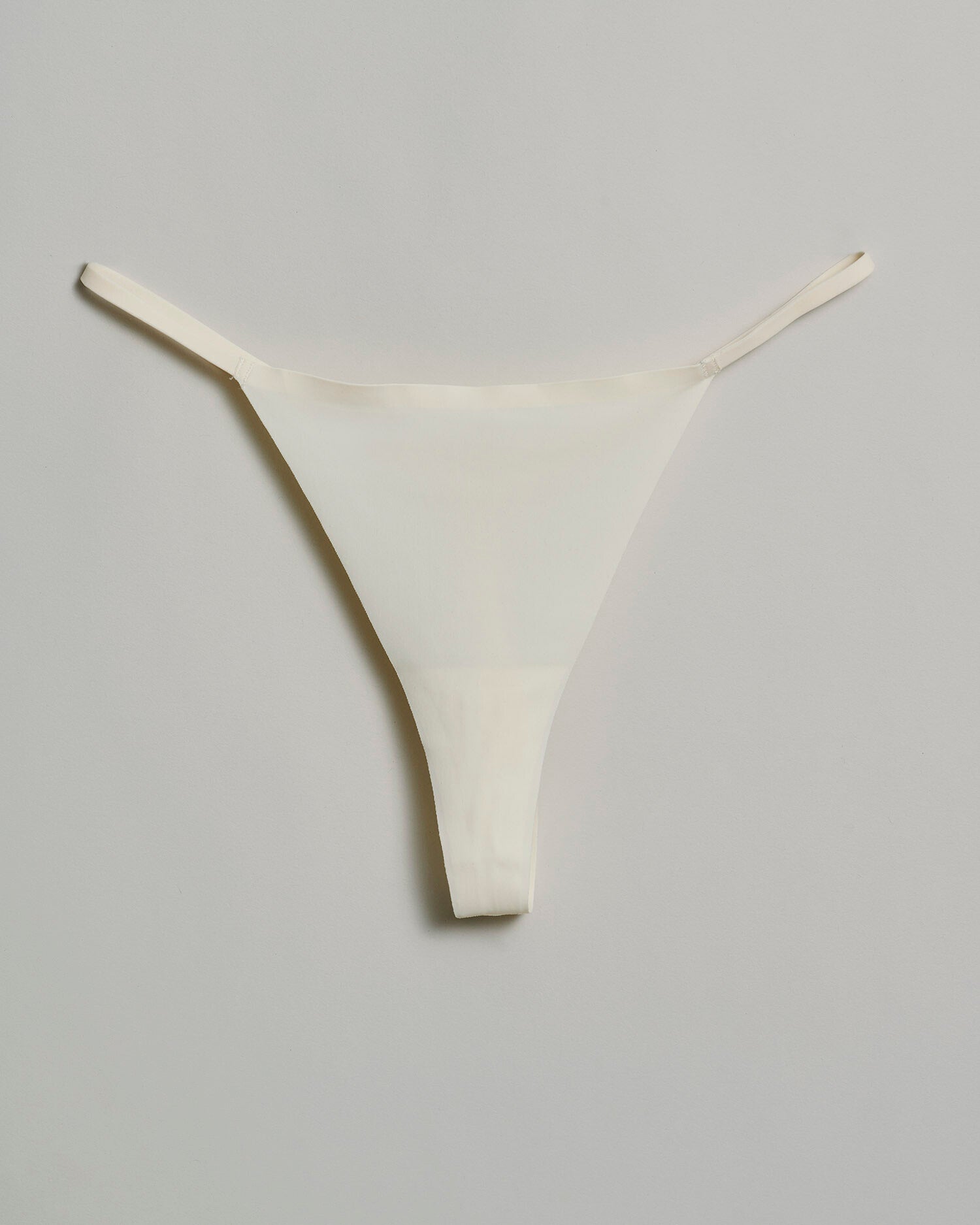 The Kim Signature T-String Thong in vanilla – soft stretch fit designed for invisible comfort and sensual confidence