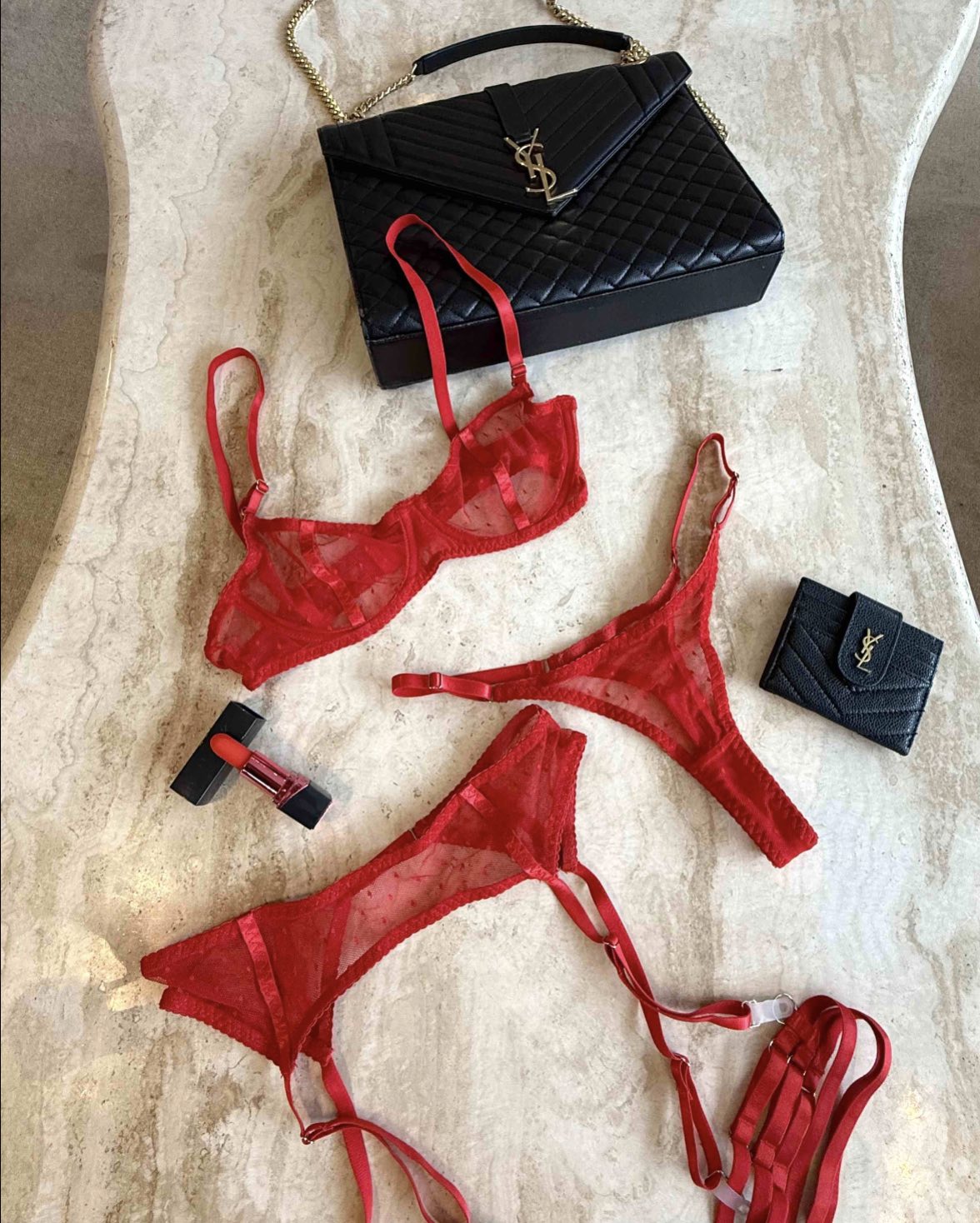 Red sheer mesh lingerie set with bra and thong styled on marble surface with black quilted bag and red lipstick, curated Valentine look by SELF Seductions.