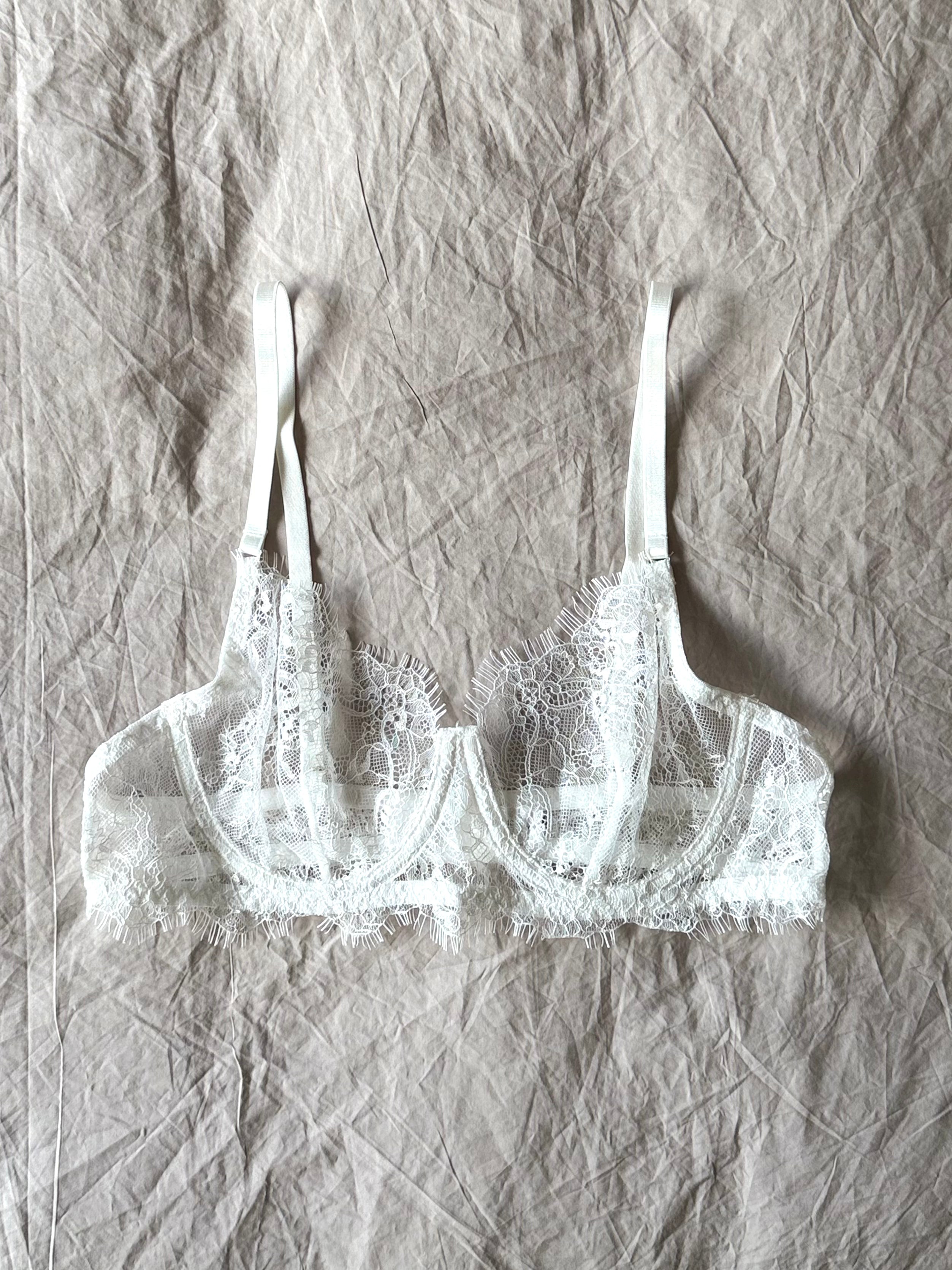 The Emma Soft Stretch Lace Bra in white – delicate lace lingerie styled on softly wrinkled linen bedding by SELF Seductions