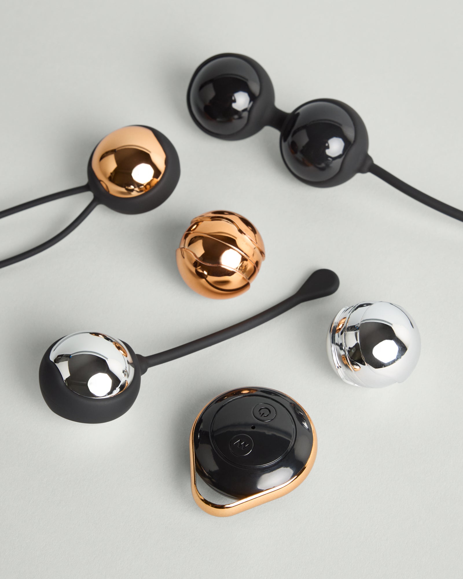Kegel training set in silicone with multiple weighted balls arranged on grey background in natural studio light