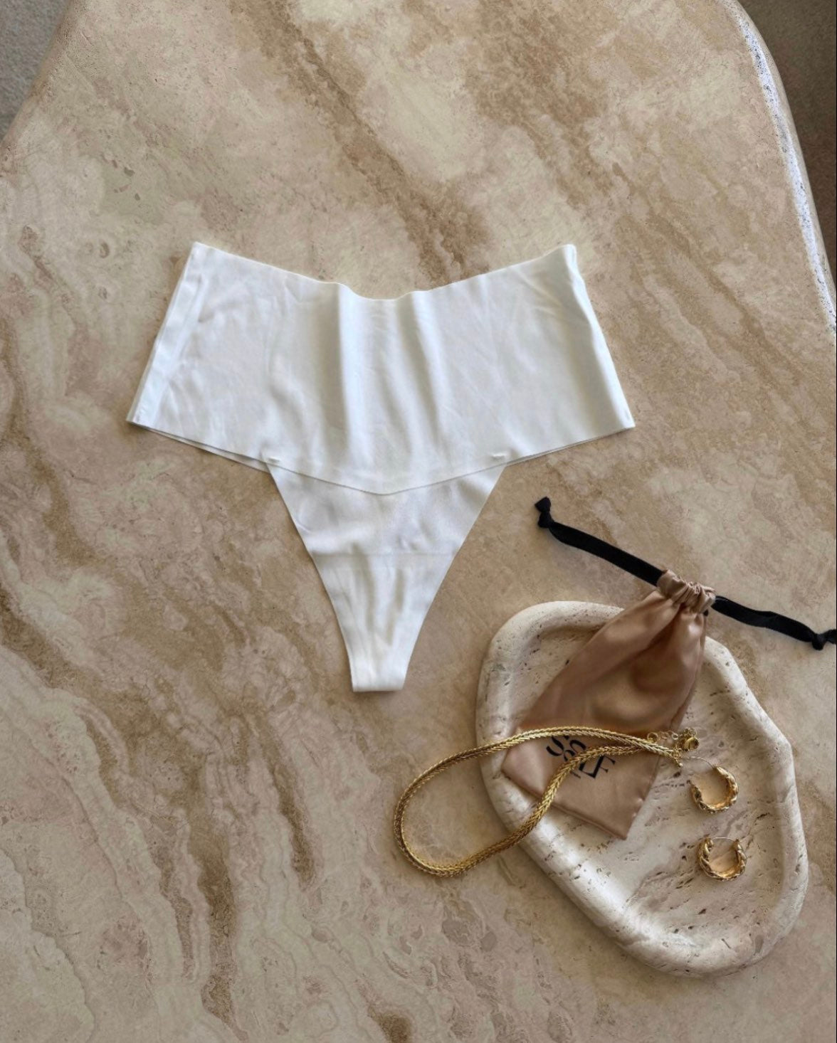 The Kourtney Seamless Sports High Waist Thong in white styled with delicate jewelry on soft marble surface – elegant and refined flatlay by SELF Seductions