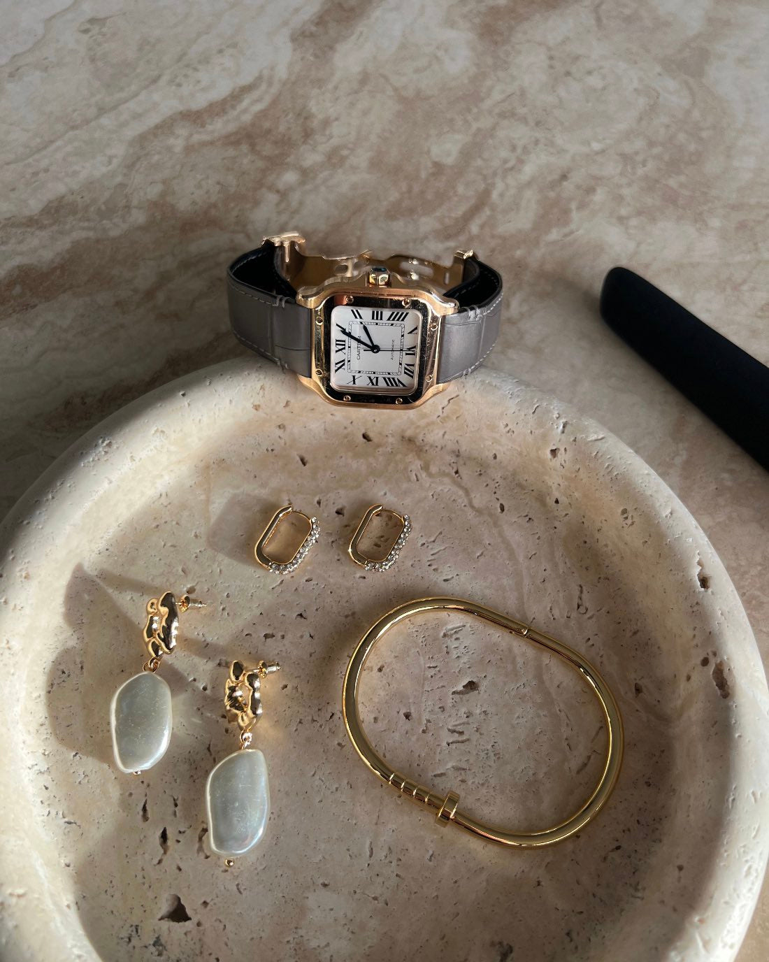 Close-up of The Allegra Gold-Plated Crystal Hoop Earrings with other gold jewelry in a stone dish by SELF Seductions