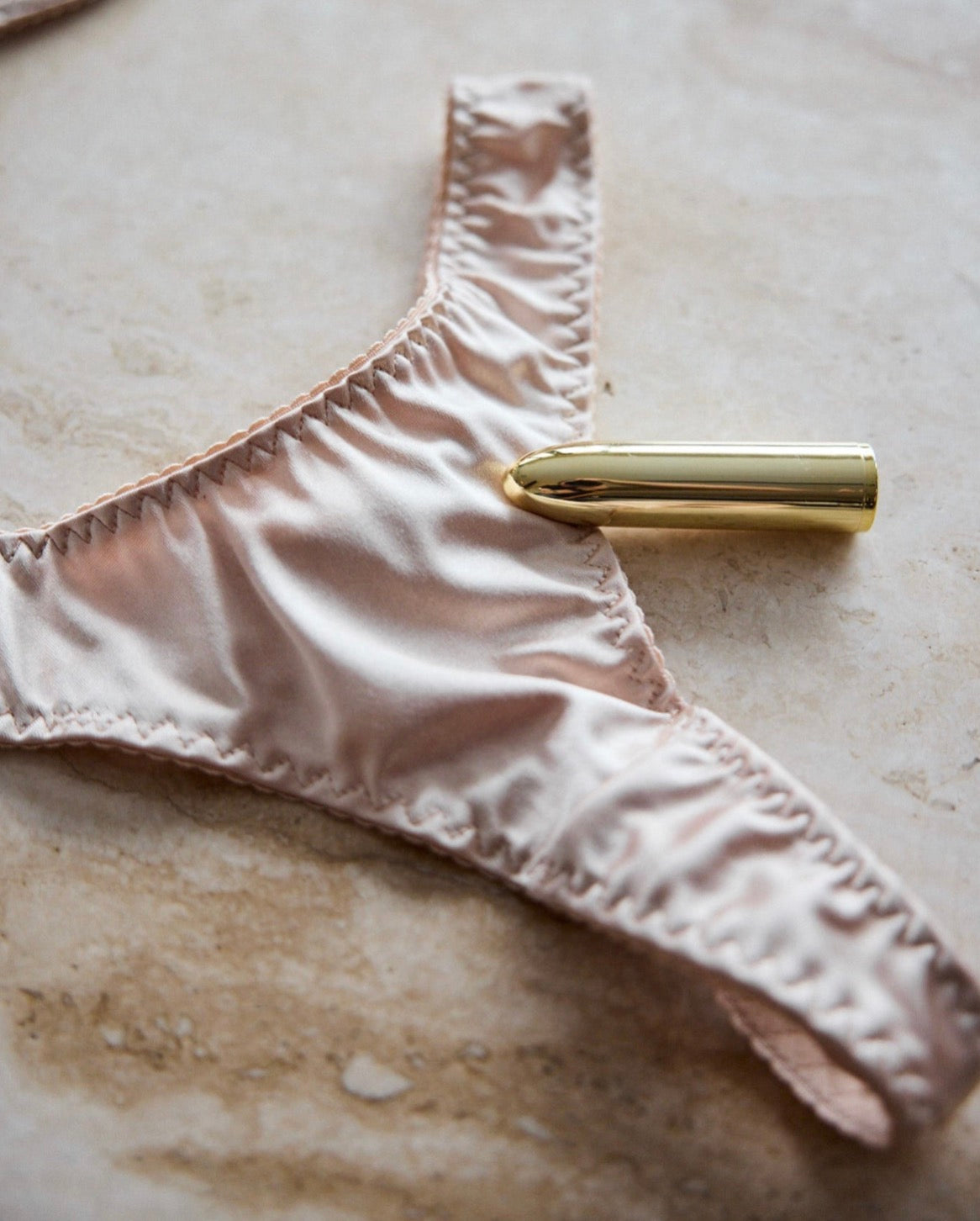 Ivory satin thong by SELF Seductions – detailed view with gold accessory for a refined, sensual look