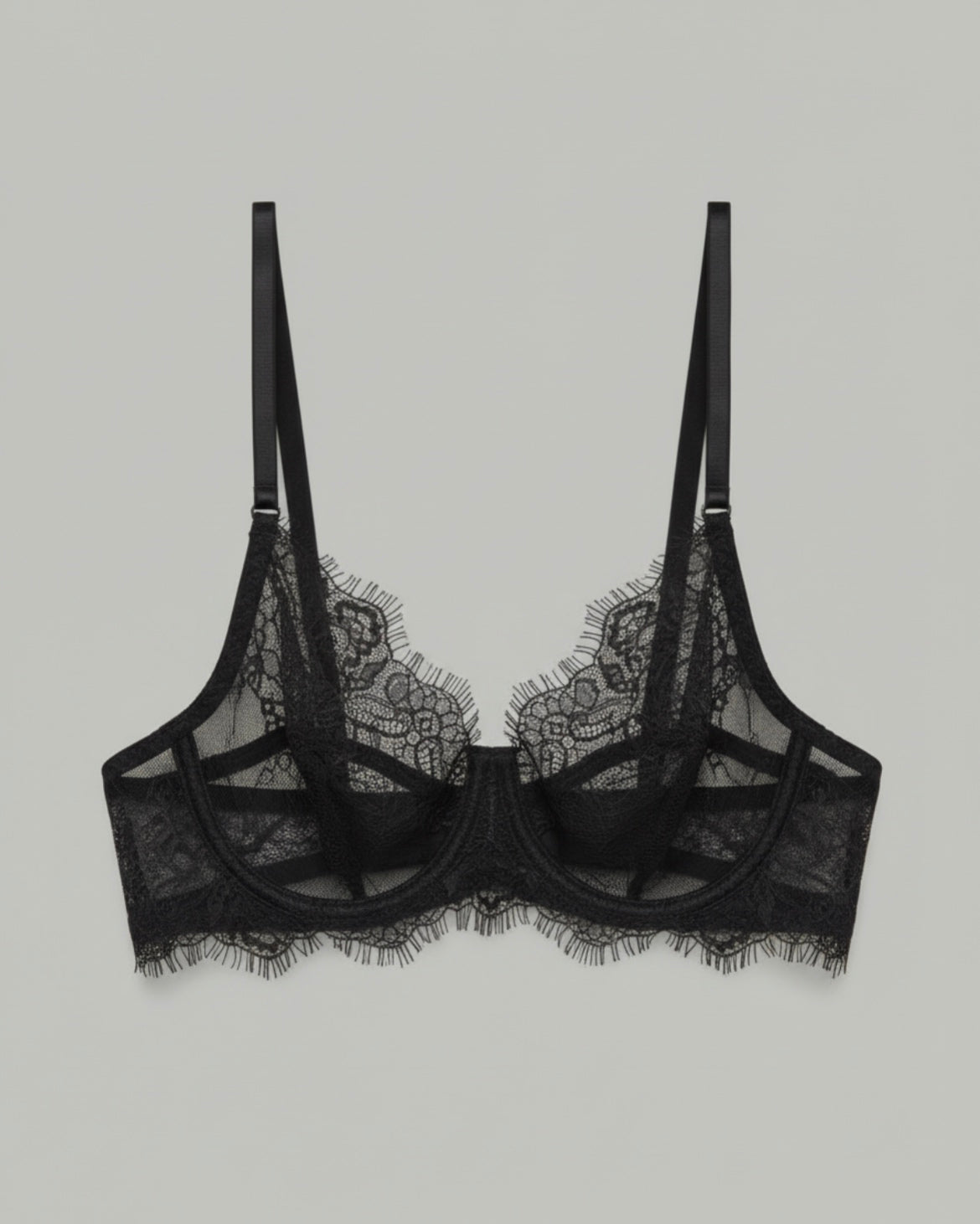 Black lace bralette in soft stretch floral lace, photographed in studio against a neutral grey background, featuring a minimal and elegant design.