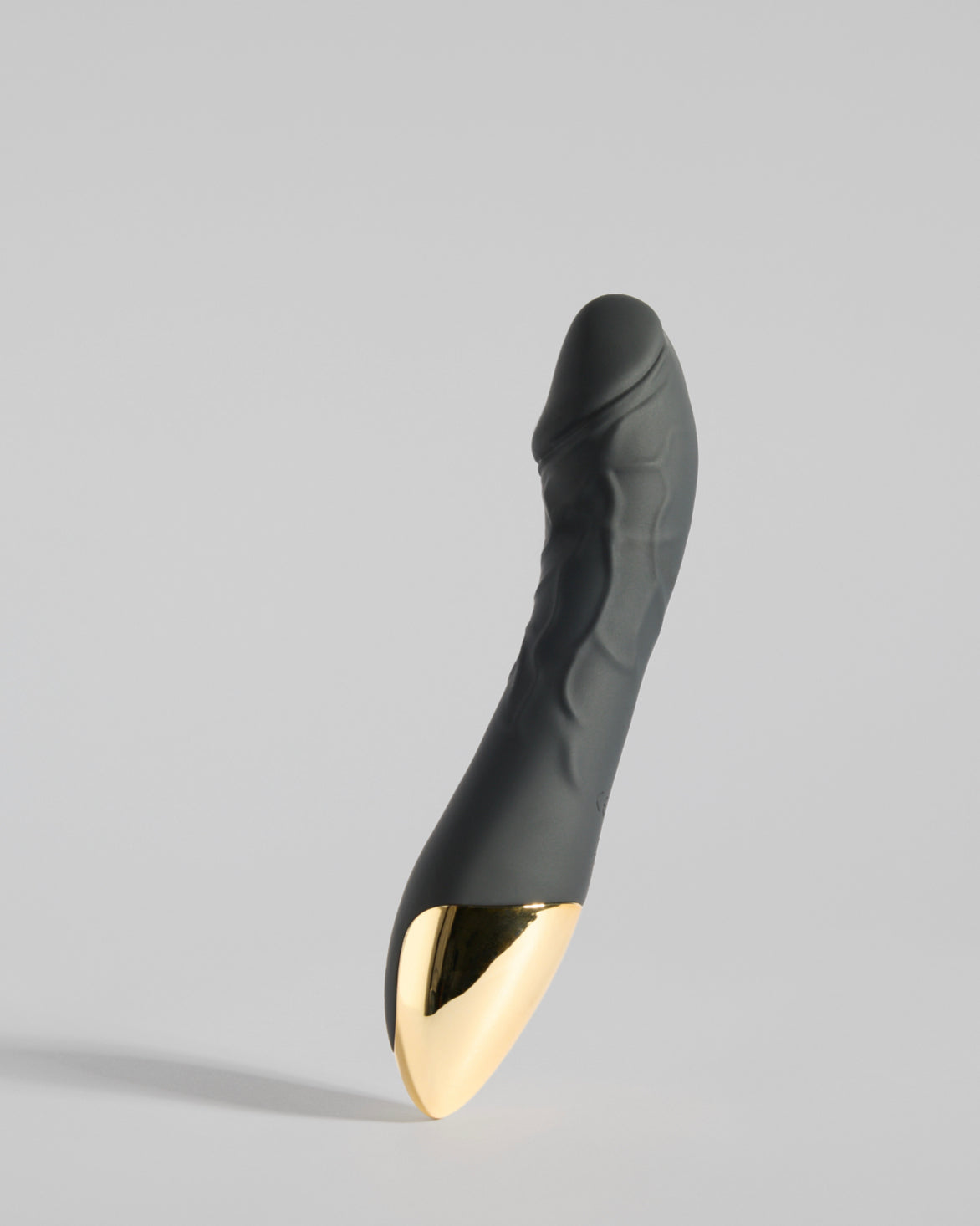 Sleek curved black wellness device with gold detail – refined and balanced design by SELF Seductions