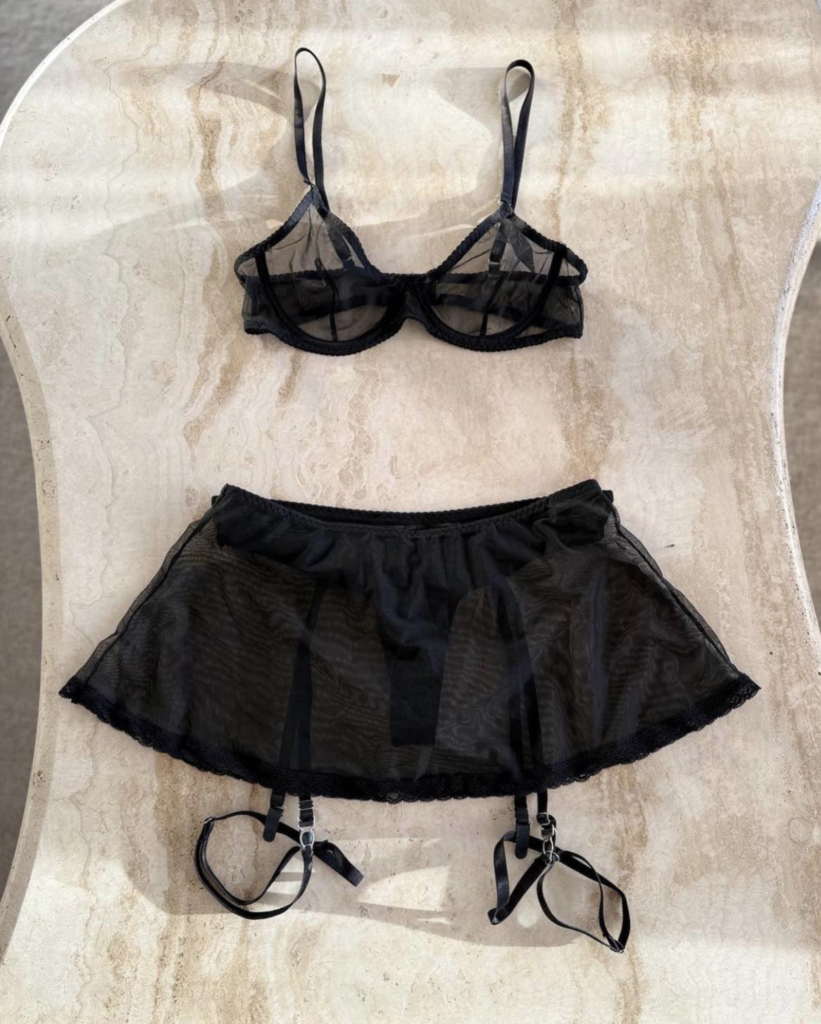 black mesh underwear set in softa natural light against travertine table