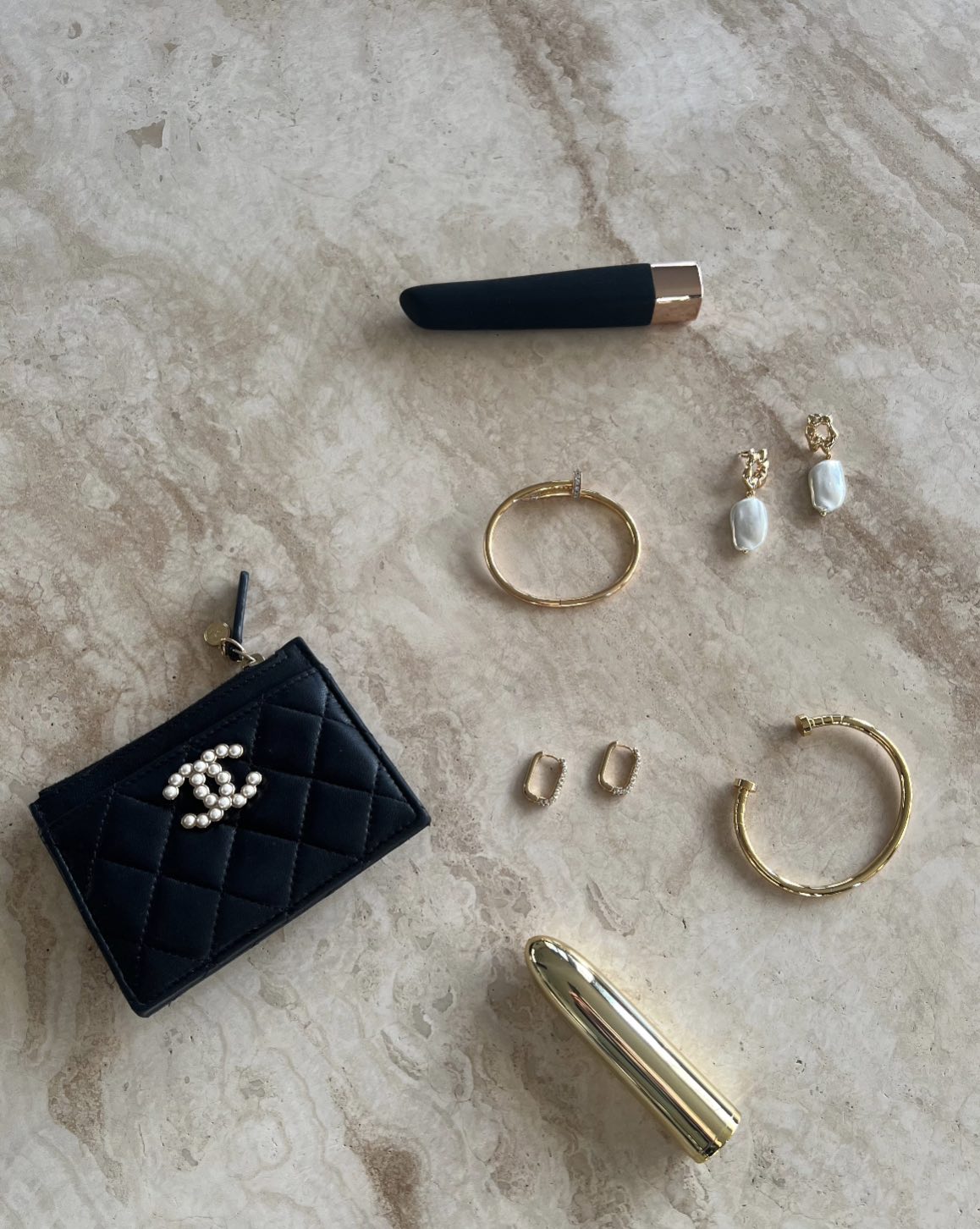The Alaïa Gold-Plated Bracelet styled with gold jewelry and accessories on a marble surface by SELF Seductions