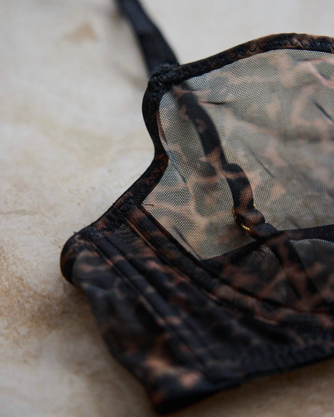 Close-up detail of The Yves Leopard Mesh Brassiere in sheer leopard print mesh, highlighting the fine mesh texture and structured cup design.